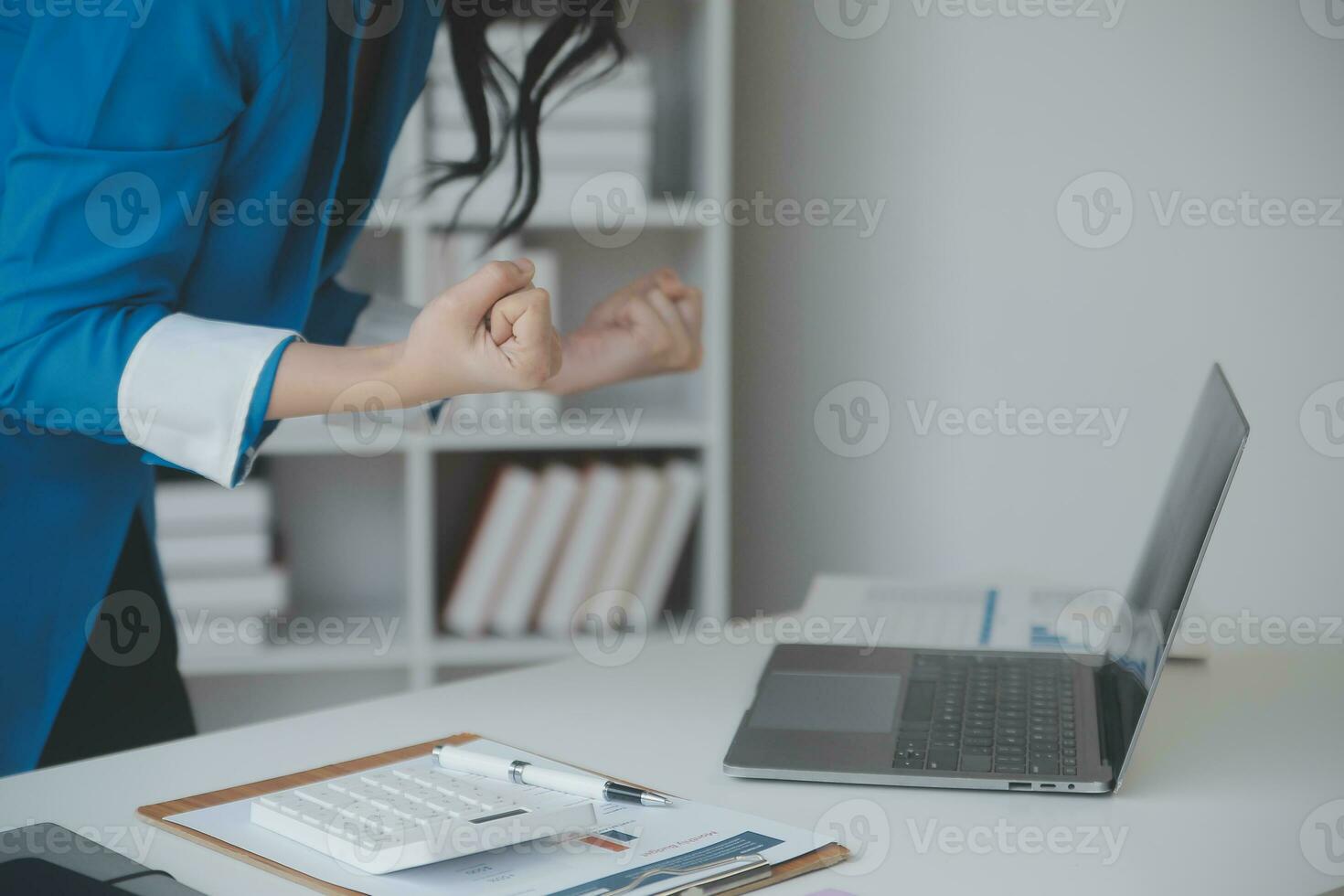Asian Business woman using calculator and laptop for doing math finance on an office desk, tax, report, accounting, statistics, and analytical research concept photo
