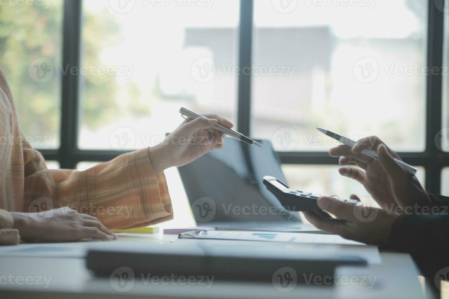 Asian Business woman using calculator and laptop for doing math finance on an office desk, tax, report, accounting, statistics, and analytical research concept photo