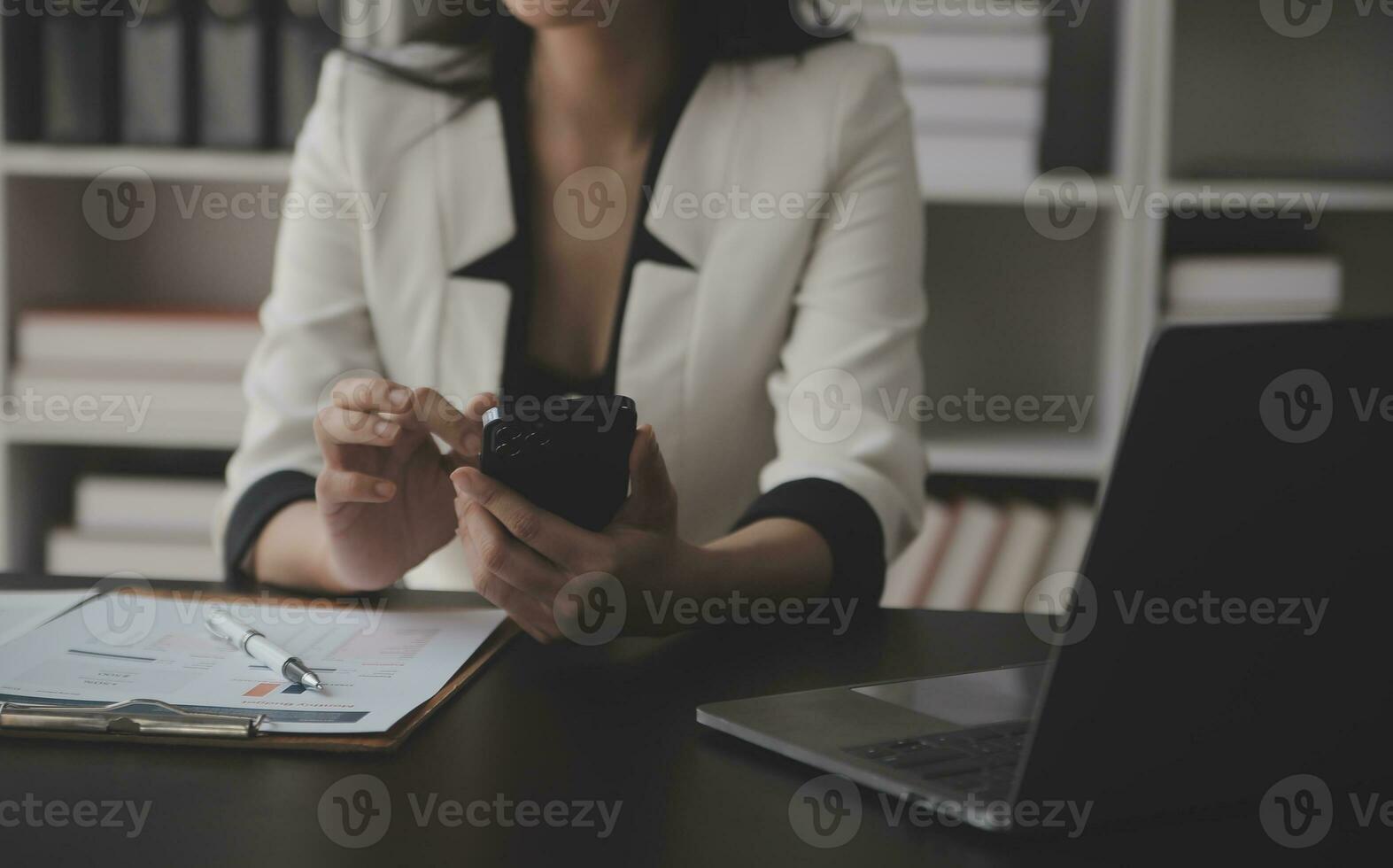 Asian Business woman using calculator and laptop for doing math finance on an office desk, tax, report, accounting, statistics, and analytical research concept photo