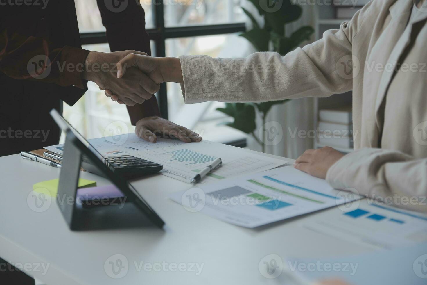 Asian Business woman using calculator and laptop for doing math finance on an office desk, tax, report, accounting, statistics, and analytical research concept photo