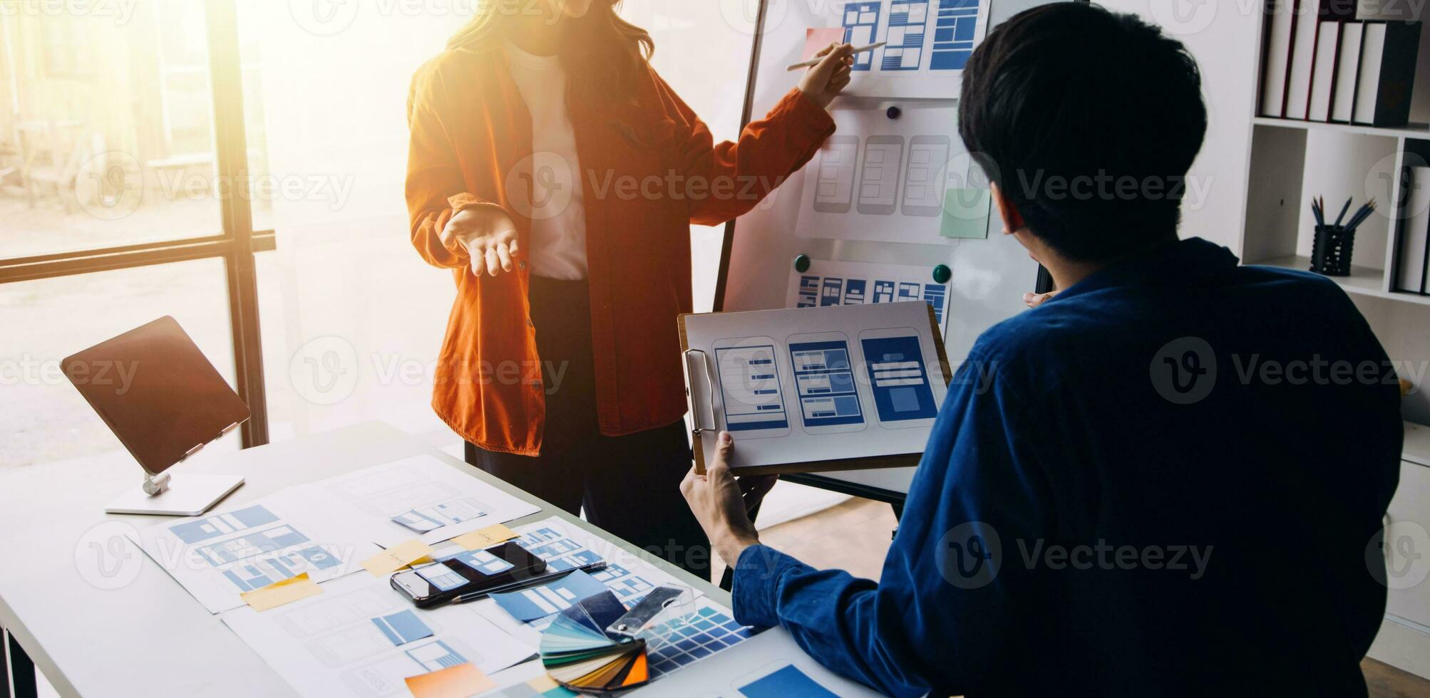 Close up ux developer and ui designer brainstorming about mobile app interface wireframe design on table with customer breif and color code at modern office.Creative digital development agency photo