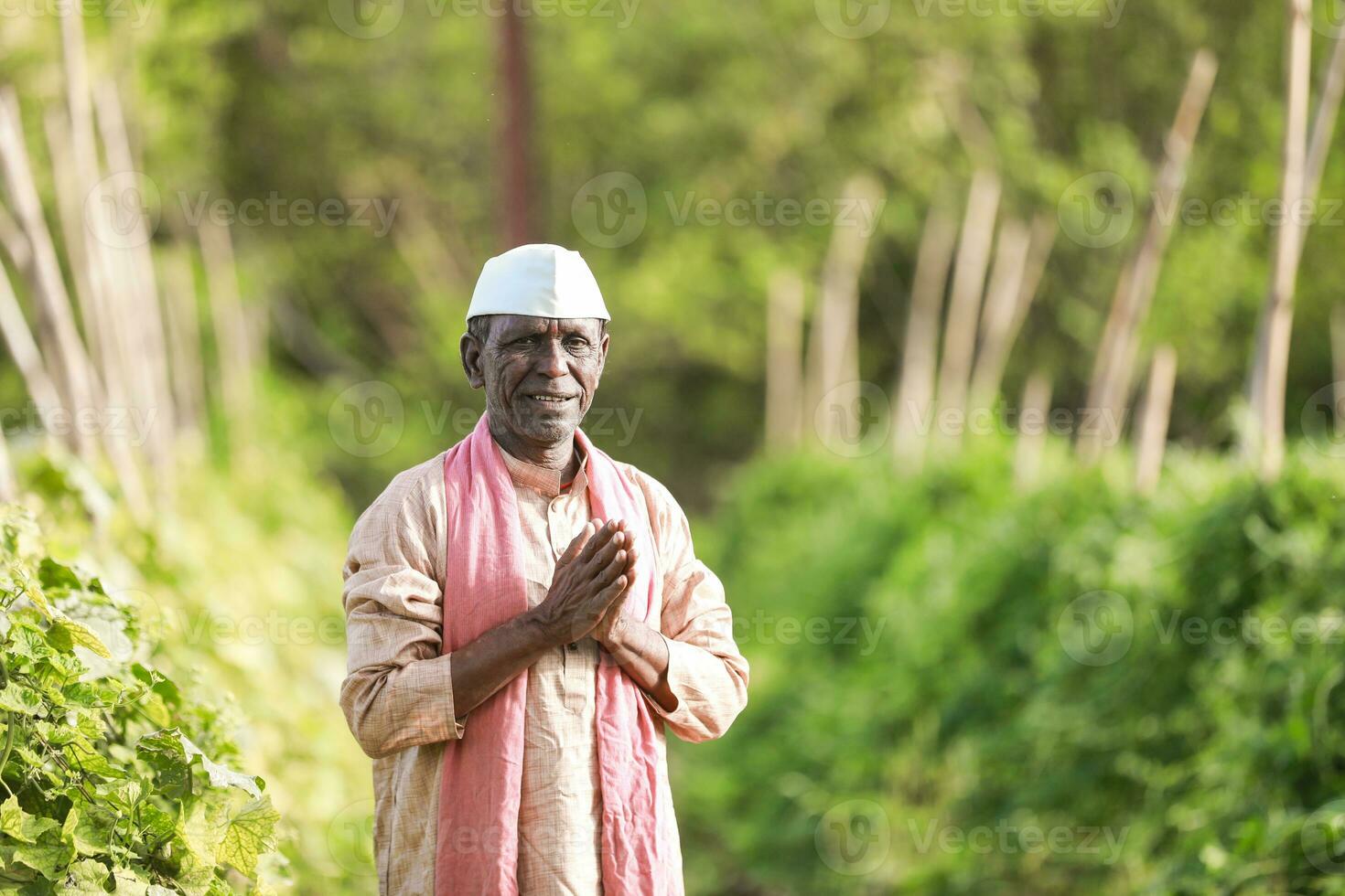 Indian farming Happy indian farmer standing in farm, sowing Empty Hands photo