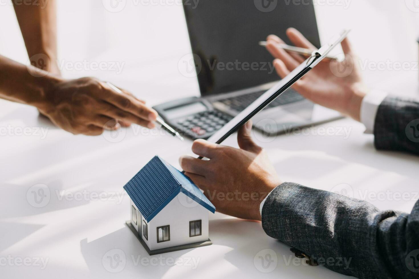 Real estate broker agent presenting and consult to customer to decision making sign insurance form agreement, buy and sell home model, concerning mortgage loan offer for and house insurance photo