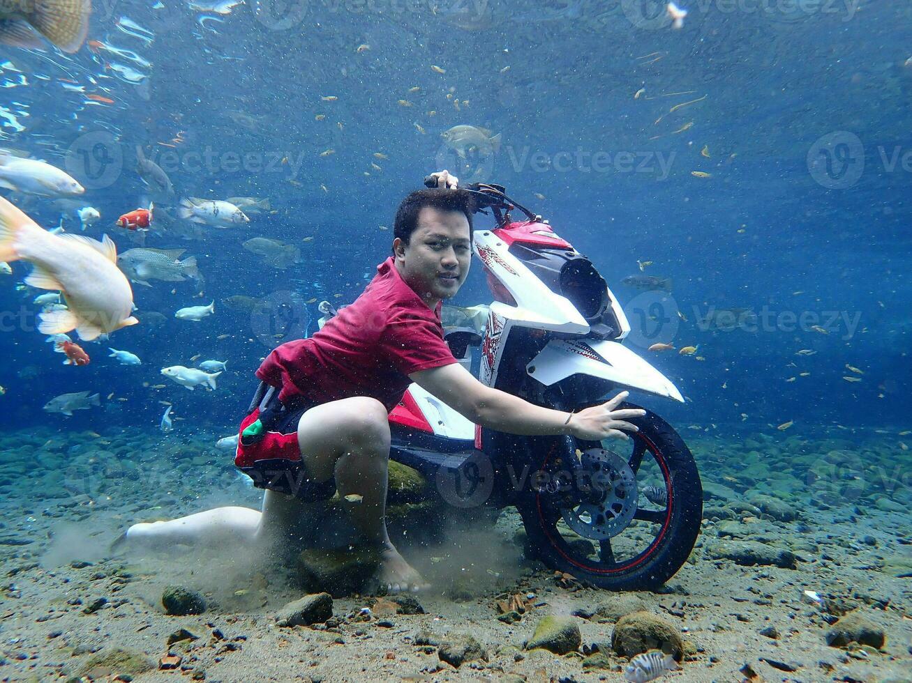 Klaten, Umbul ponggok, Indonesia, July 22, 2022,  a man taking a photo under clear water