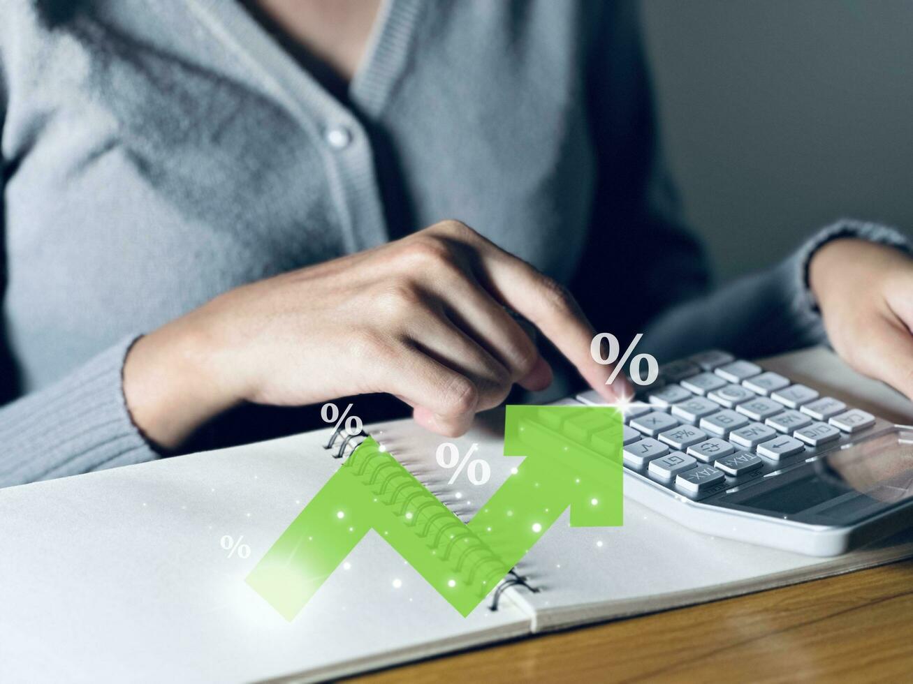 Woman using a calculator to calculate the company's revenue and profit percentage For dividend payment, cash reserve, provident fund. photo