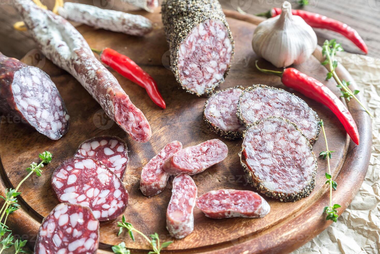 Slices of saucisson, fuet and salami on the wooden board 25232121 Stock