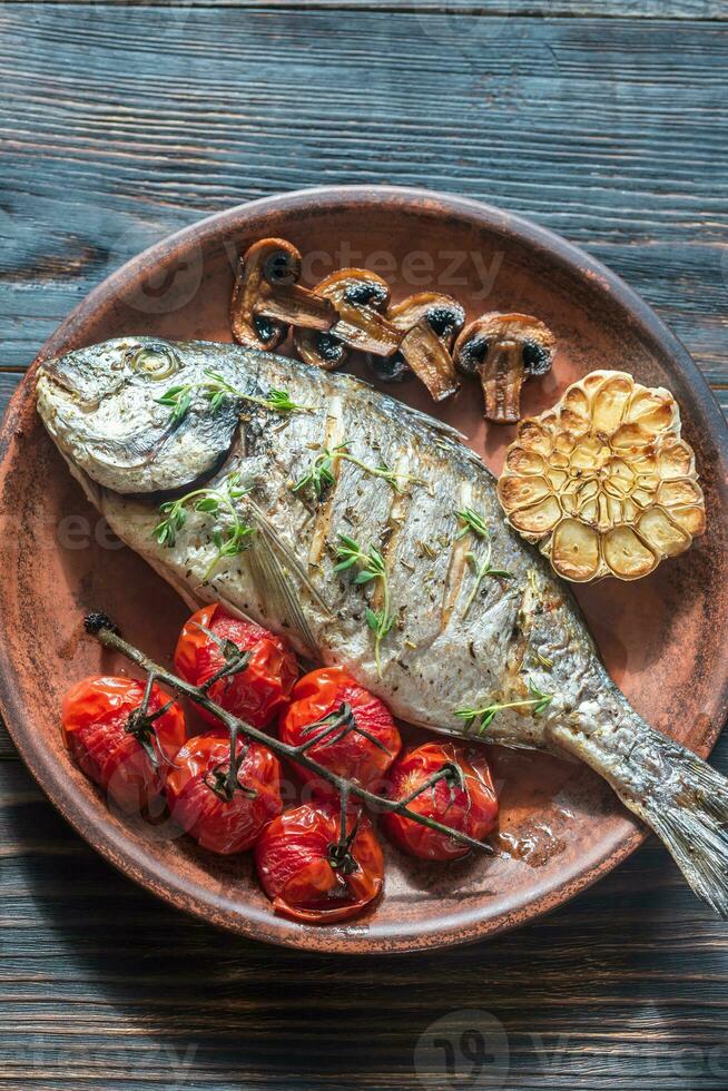 Grilled fish with thyme and cherry tomatoes photo