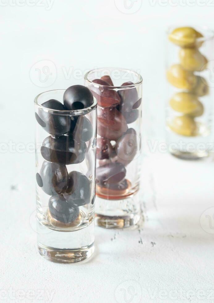 Assortment of three species of olives in glasses photo