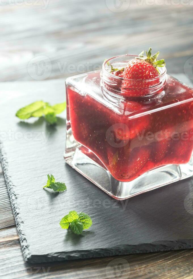 Glass jar of strawberry jam photo