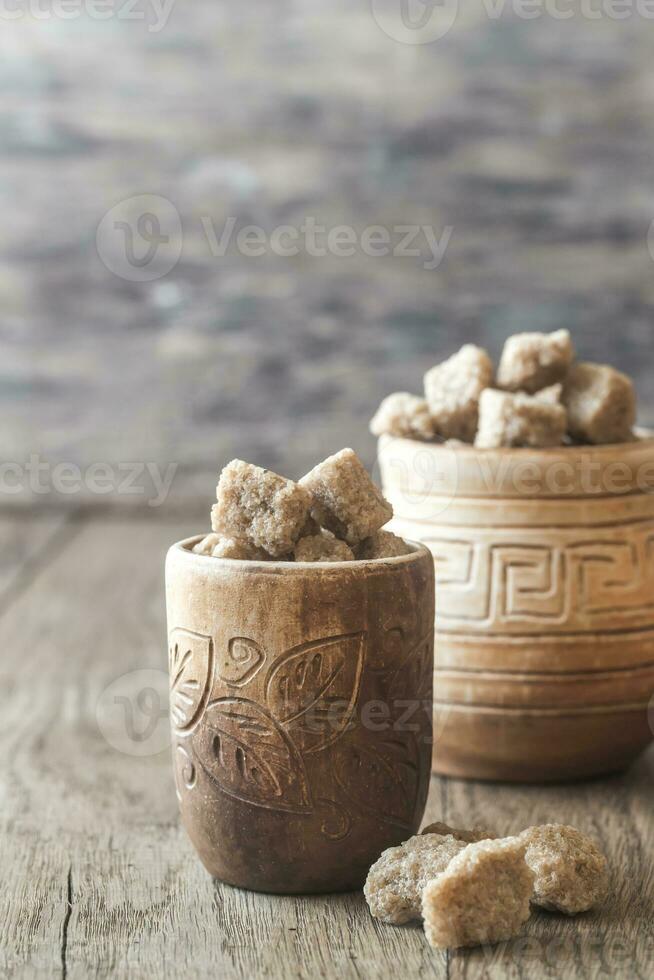 Bowls of brown sugar on the wooden background photo