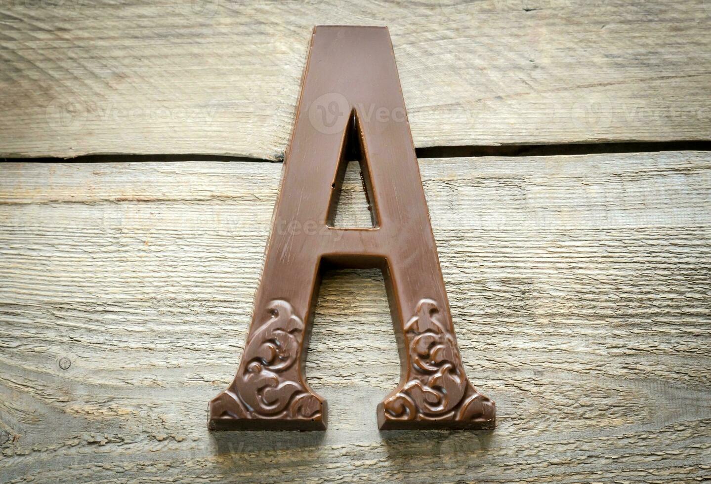 Chocolate letter on the wooden background photo