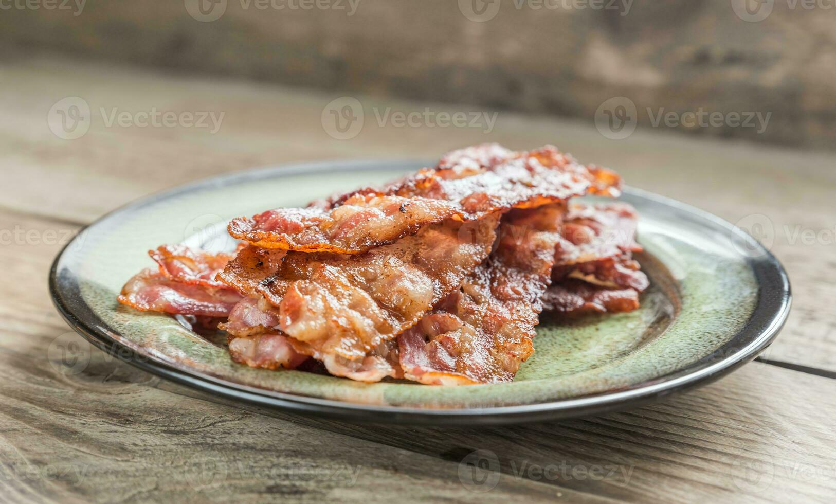 Stack of fried bacon strips on the plate photo