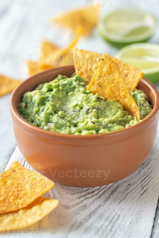 tazón de guacamole con chips de tortilla foto