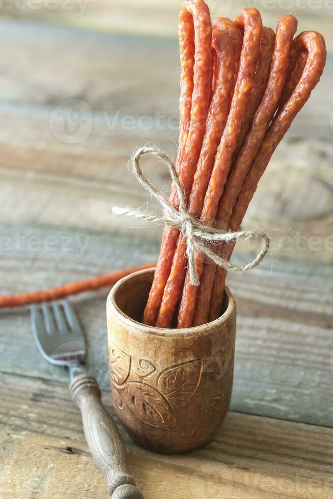 Smoked sausages on the wooden background photo