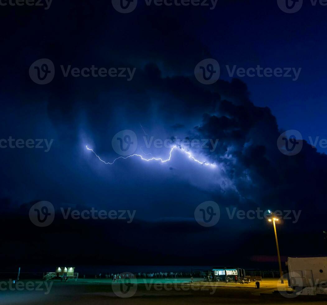 eléctrico tormenta terminado el playa, con rayos foto