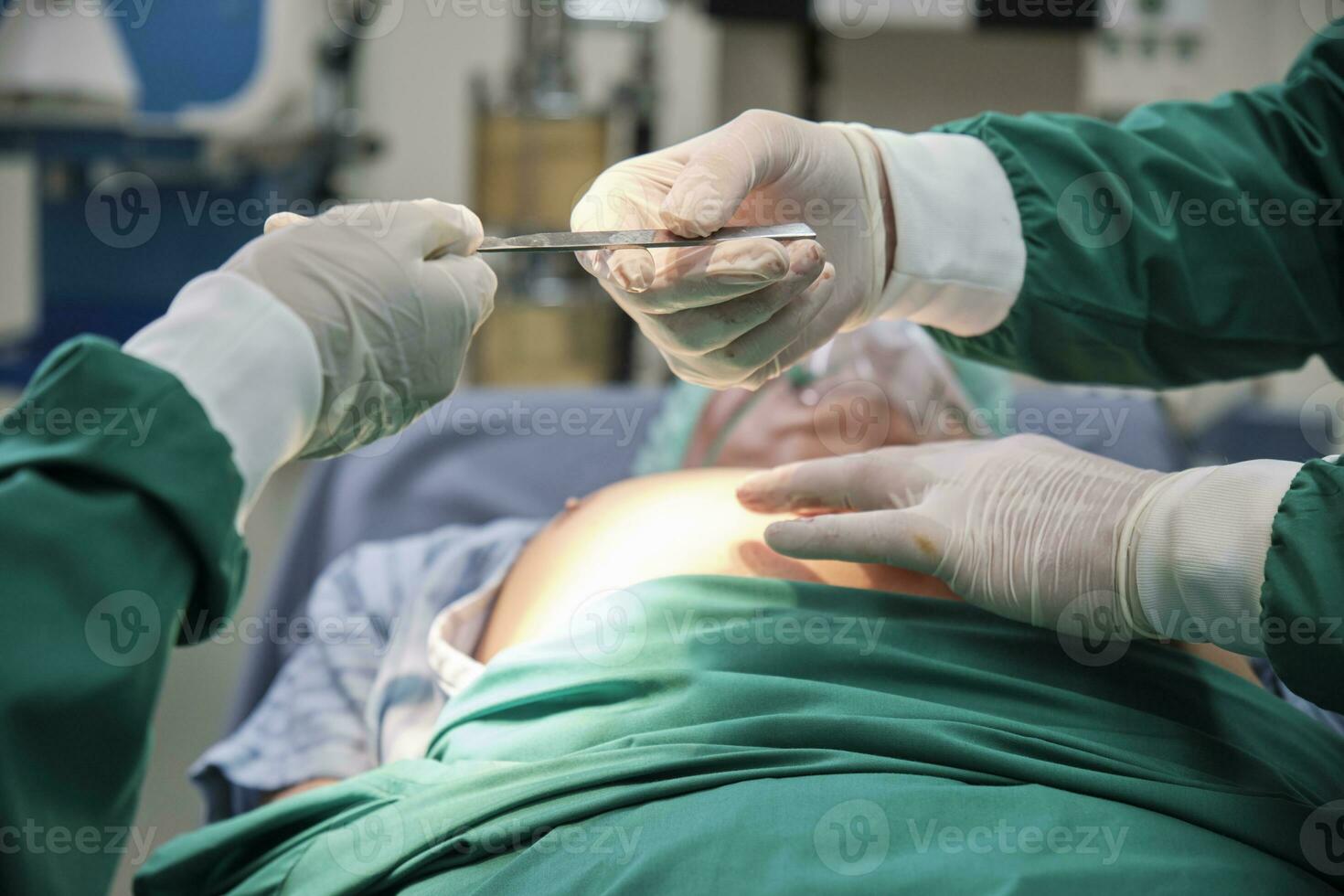 Close up, practitioner doctor gives knife to specialist surgeon's hand, prepares for surgery operations on critically ill patients in hospital's ICU, professional medical team. photo