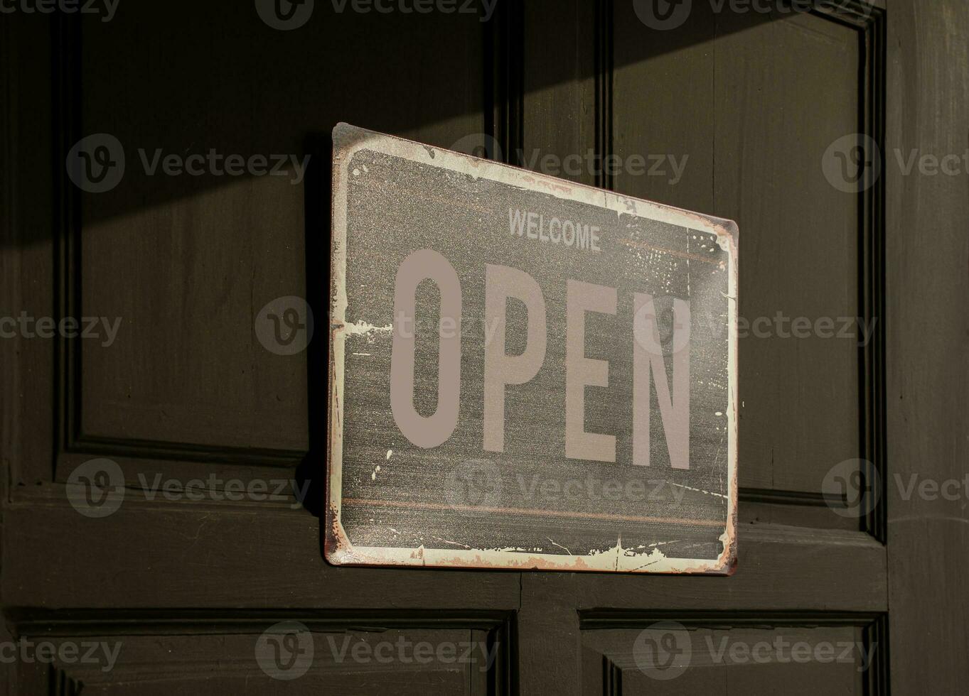 Sign with message Welcome OPEN on black wooden door photo