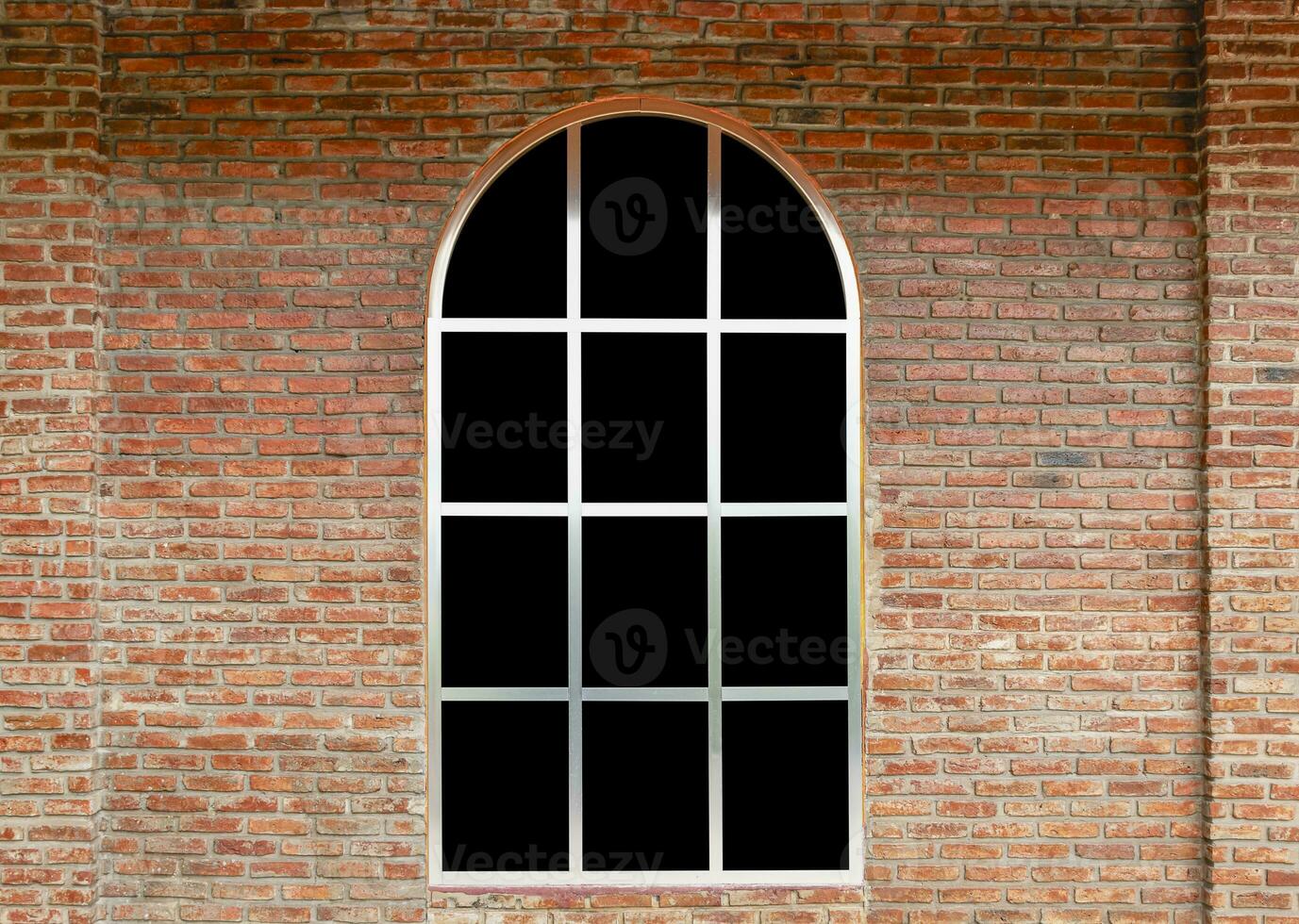 Curve window with black glass on brick wall photo