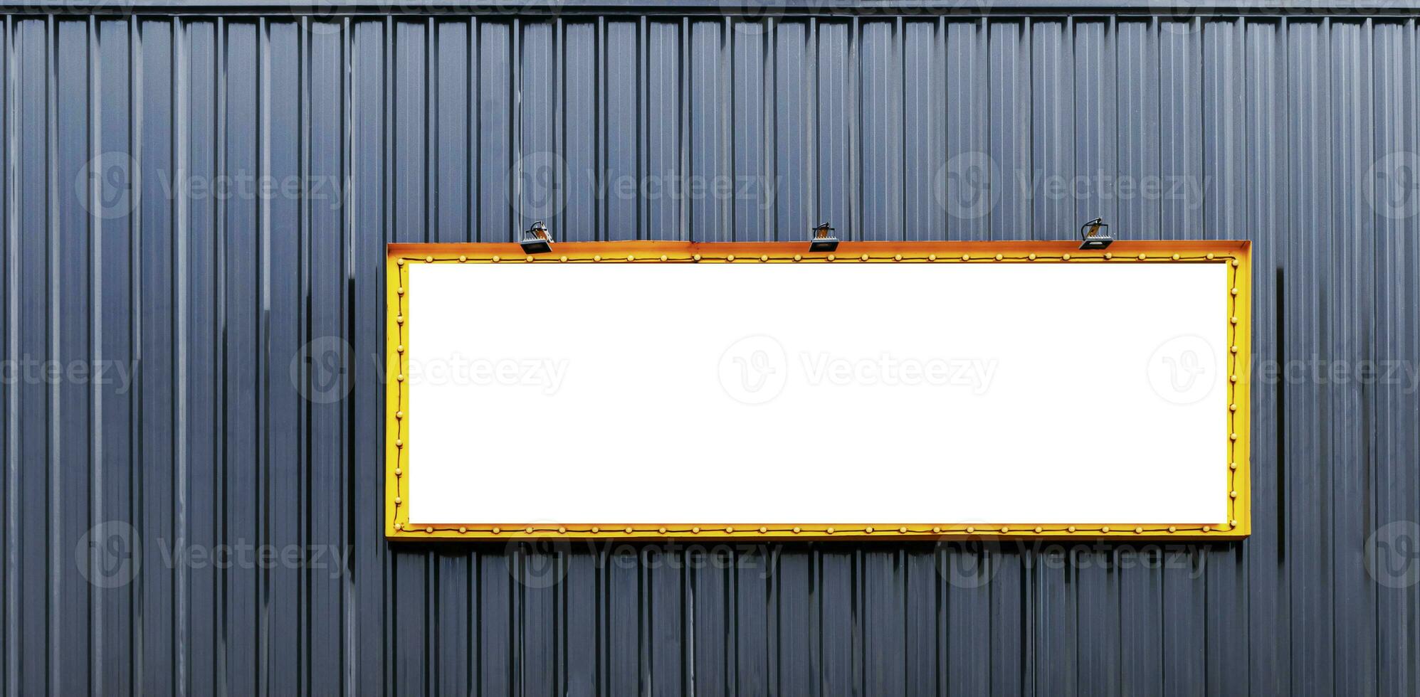 Mock up yellow picture frame billboard with spot light and light bulbs around on black wall building photo