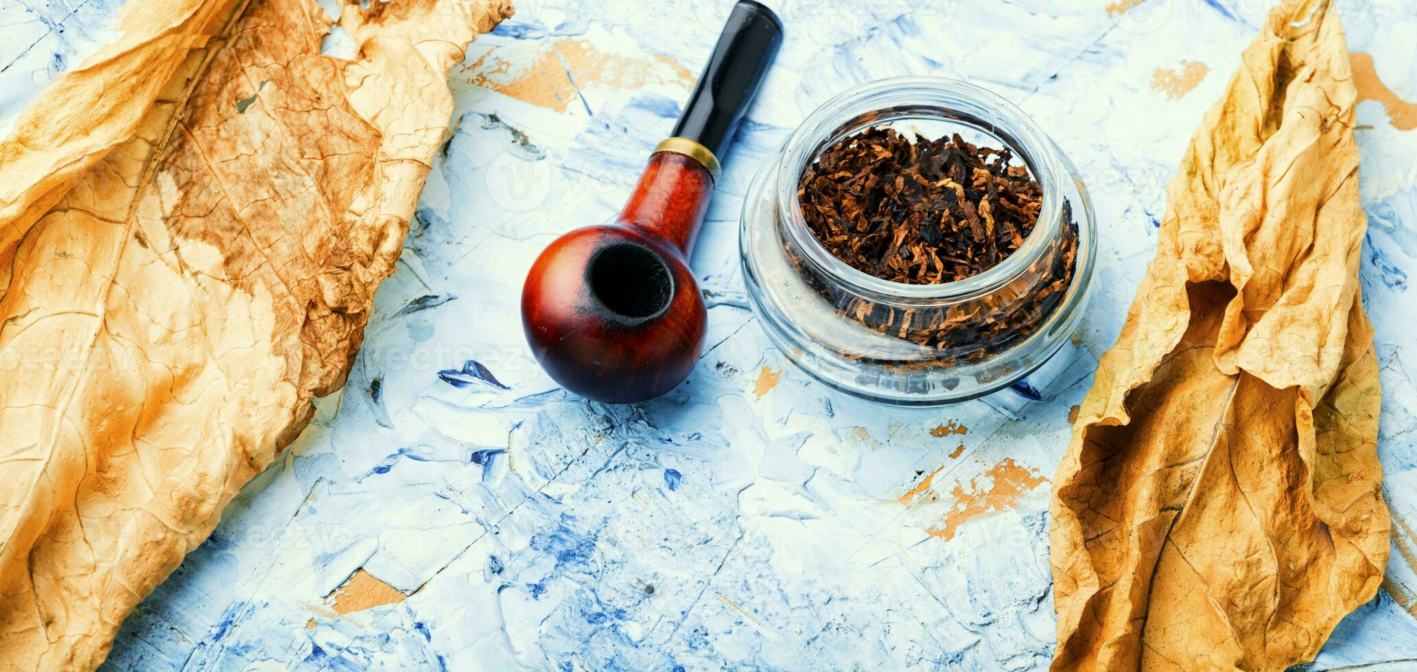 Smoking pipe with tobacco leaves photo