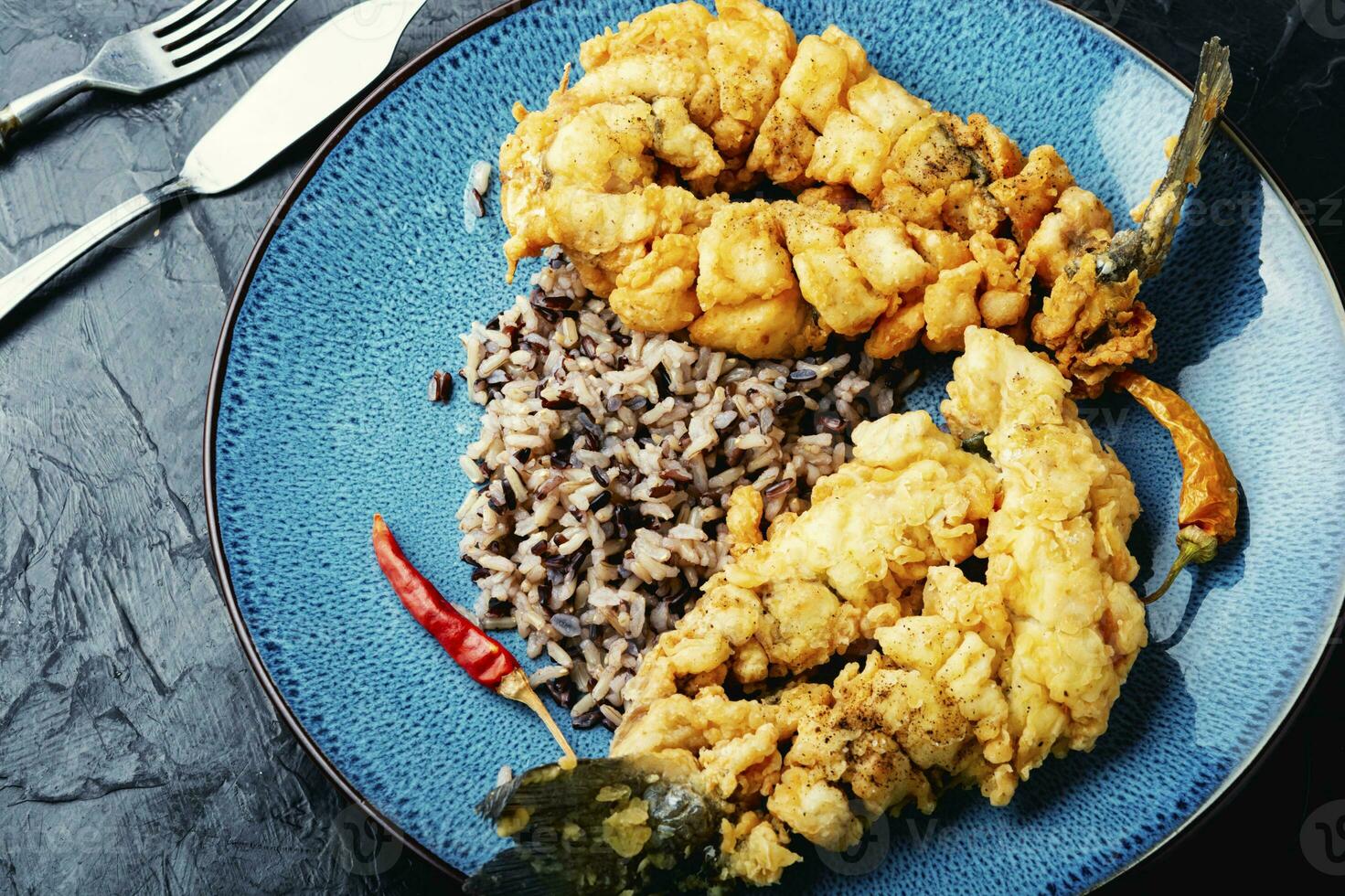 Breaded fish and rice on the plate. photo