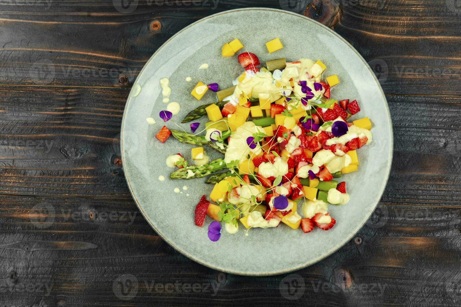 Fruit salad with asparagus on the plate. photo