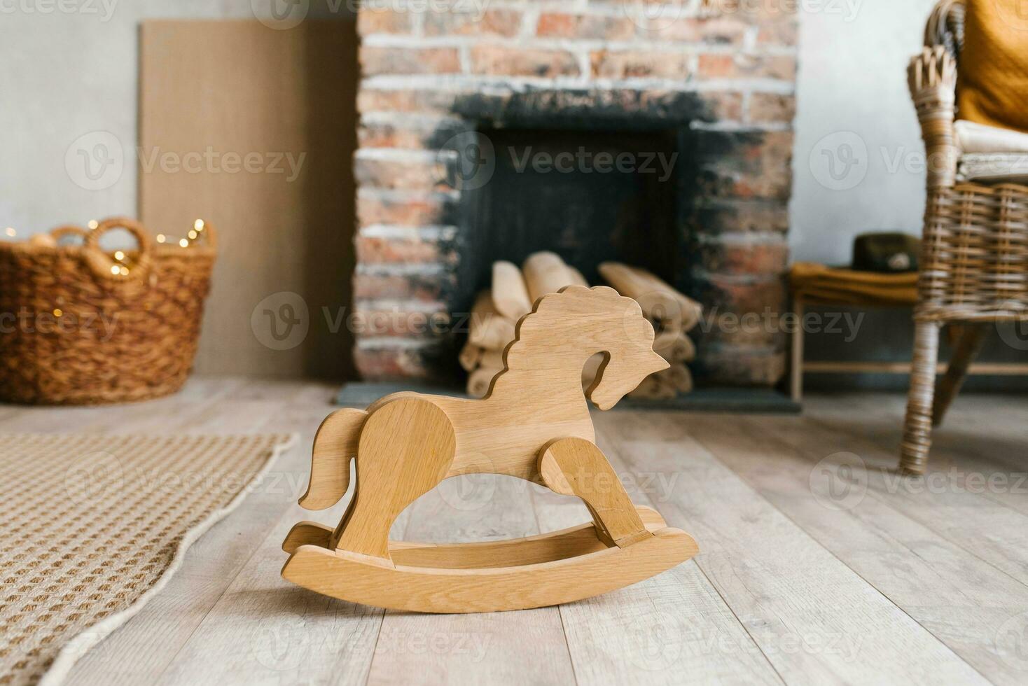 Brick fireplace with firewood, children's wooden toy horse-gurney in the living room in Scandinavian style photo