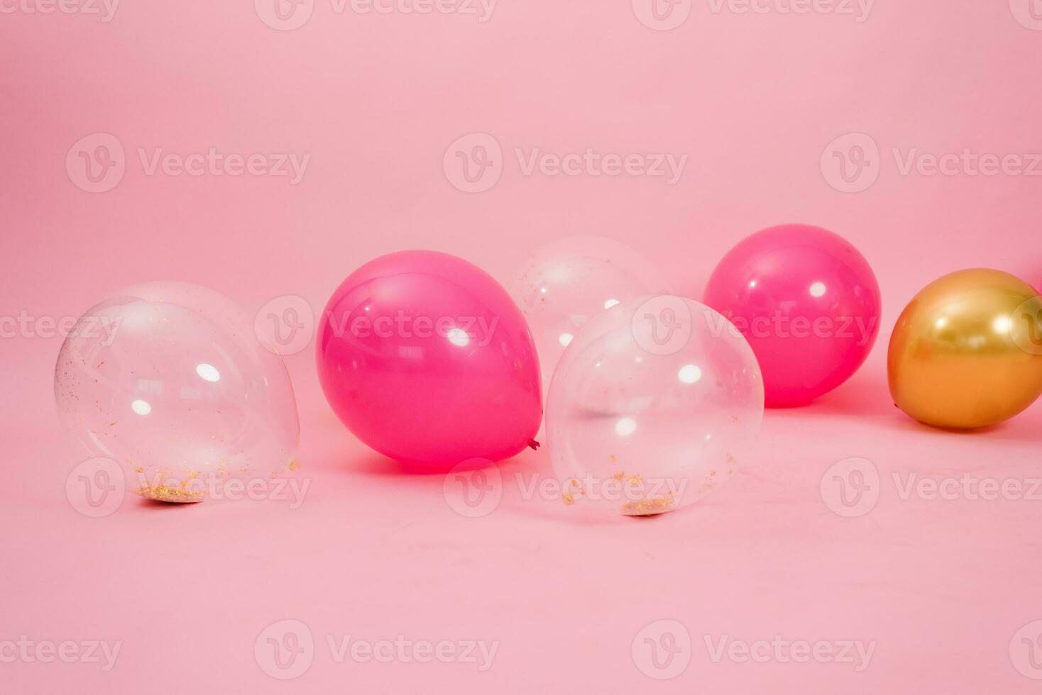 Group of multicolored transparent, pink and gold balloons lying on the floor in the house for Valentine's Day, Birthday, holiday concept photo