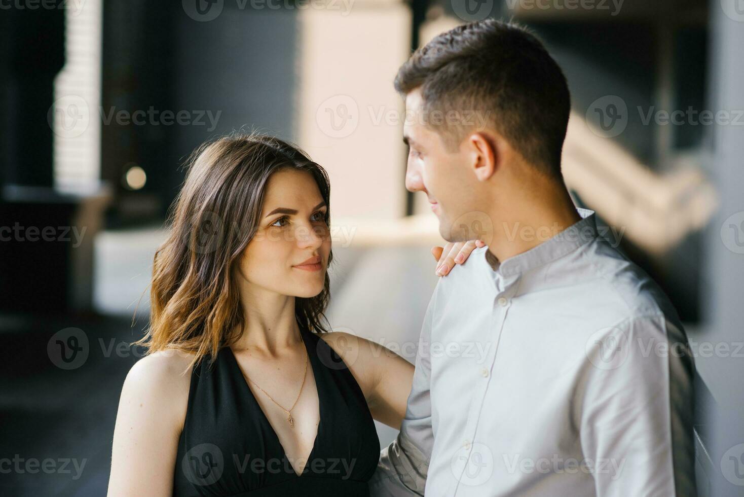 Portrait of a young beautiful couple. The girl looks into the eyes of her loved one and smiles. First date and the concept of tenderness photo