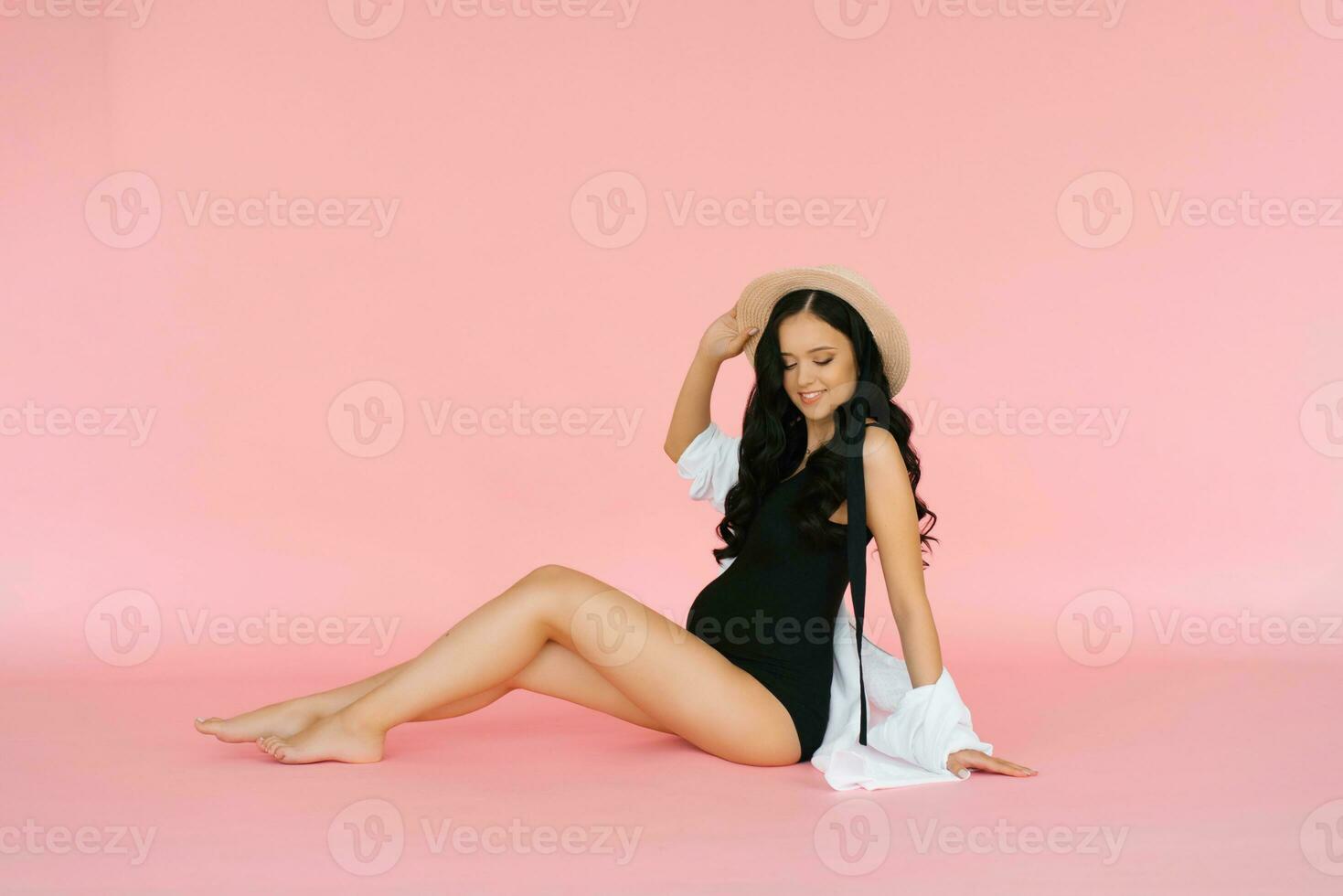 Expectant mother on a pink background. Pregnant woman waiting for the birth of a child photo