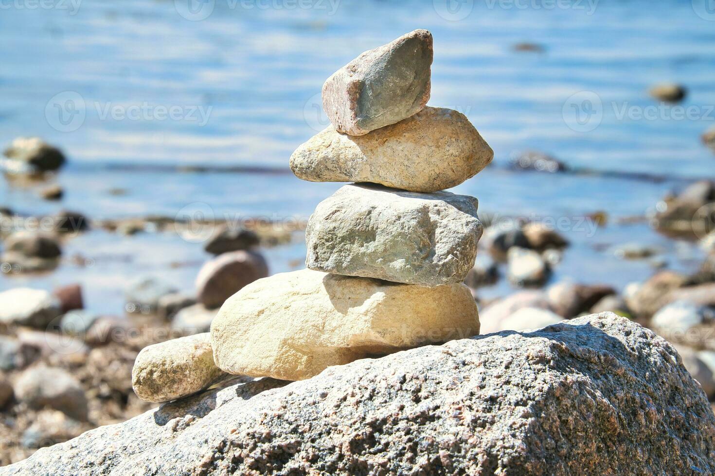 Stone pyramid on the Baltic Sea overlooking with blue sky and sunshine. Spiritual photo