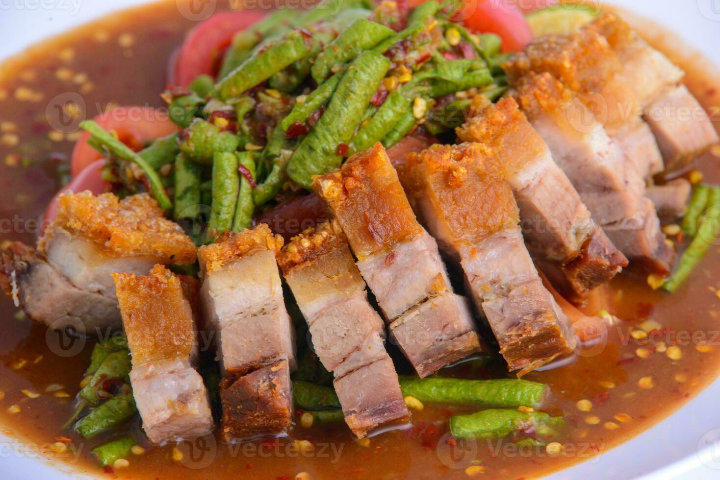 Stir fried crispy pork and green yardlong bean with red curry paste. photo