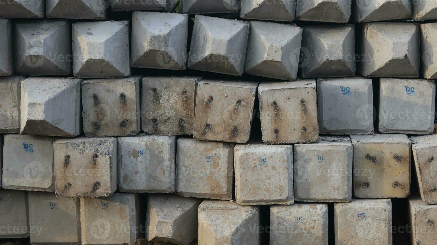 Close-up of a stack of prestressed concrete piles on the ground for construction work photo