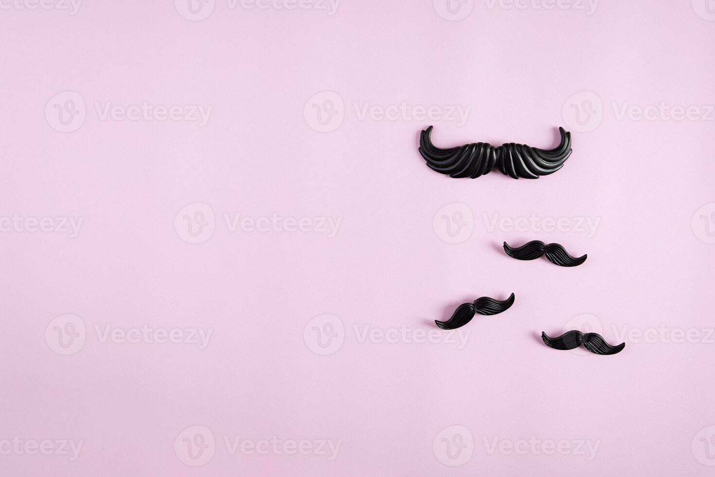Curly mustaches on colorful background. Fake mustache. Top view photo