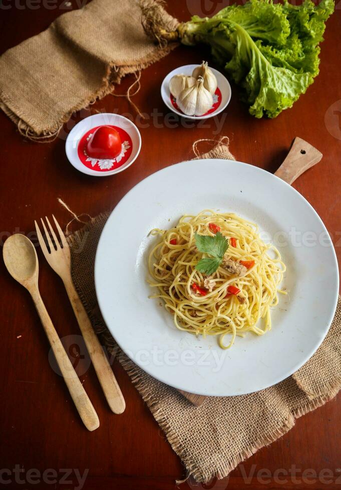 aglio mi baturrillo. italiano pasta espaguetis, aglio baturrillo mi pepperoni ,espaguetis con ajos, aceituna petróleo y chile pimientos en plato en mesa foto