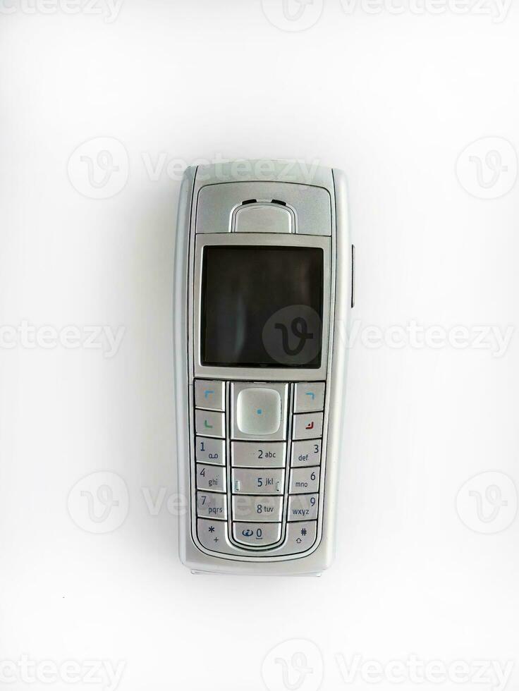 Old mobile phone isolated on white background, early wireless digital technology, communication device photo