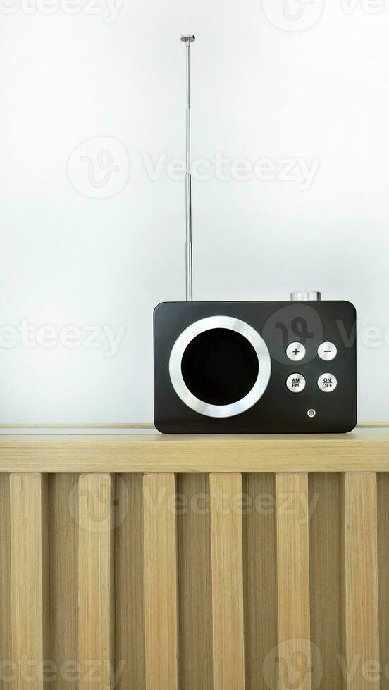 Vertical image, Retro style vintage transistor radio receiver, nostalgia, tuning function with AM and FM frequency station, on wooden counter and white background photo
