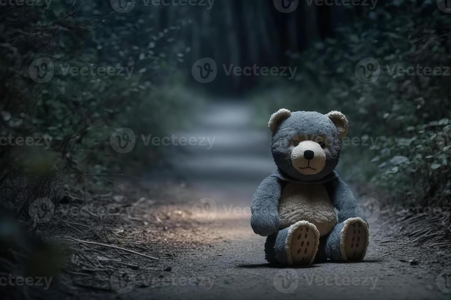 Plush lonely abandoned bear toy on path in dark forest, outdoors. Concept of loss of child, children's abuse, end of childhood. photo