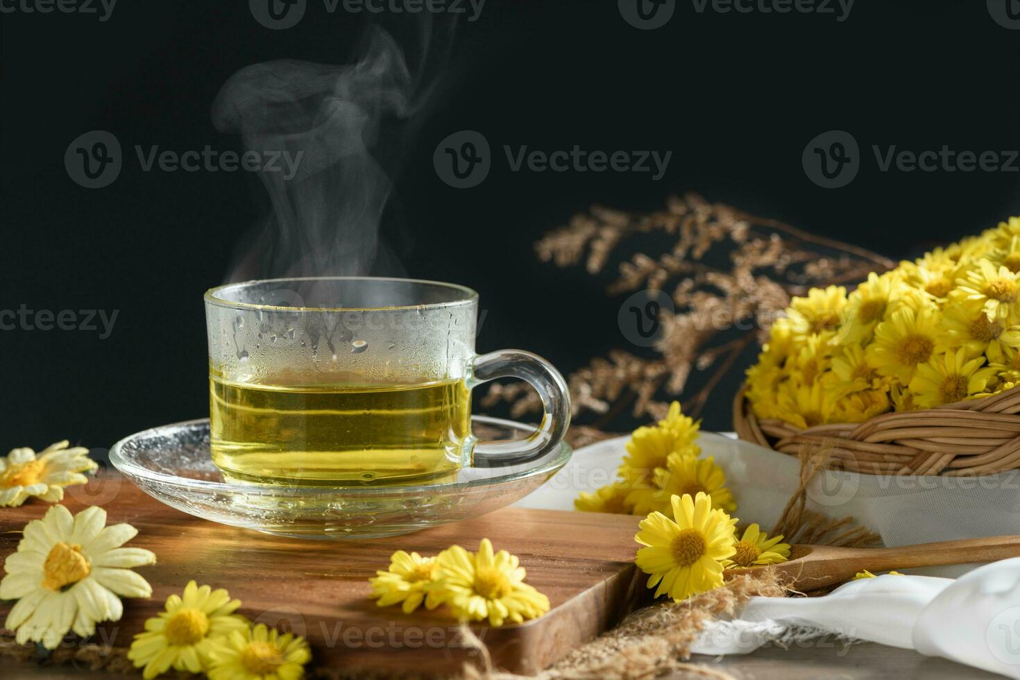 Chrysanthemum tea with hot steam and Chrysanthemum flower in basket on black background. photo