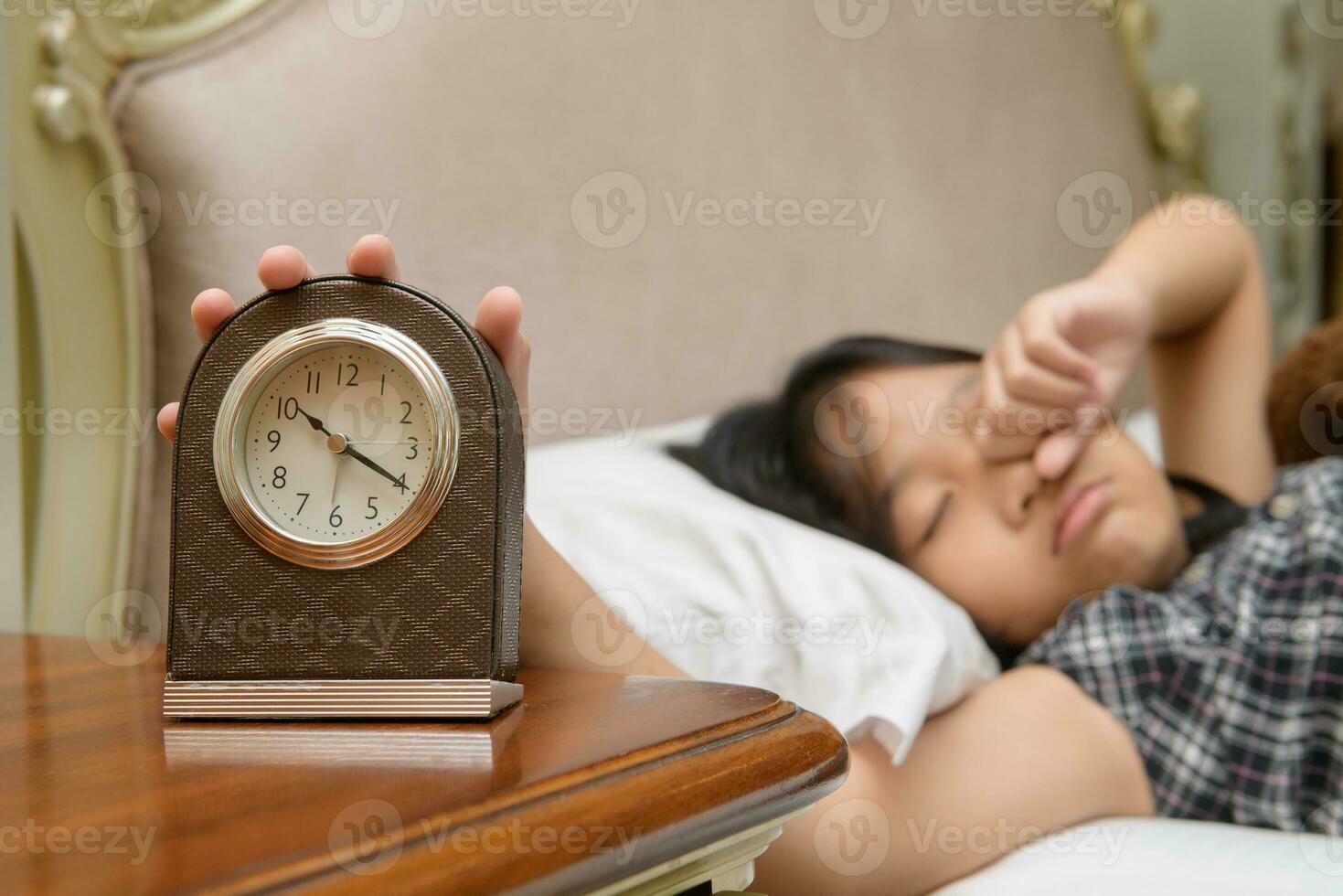 Hand girl reaching out for alarm clock, lazy and Wake up late photo