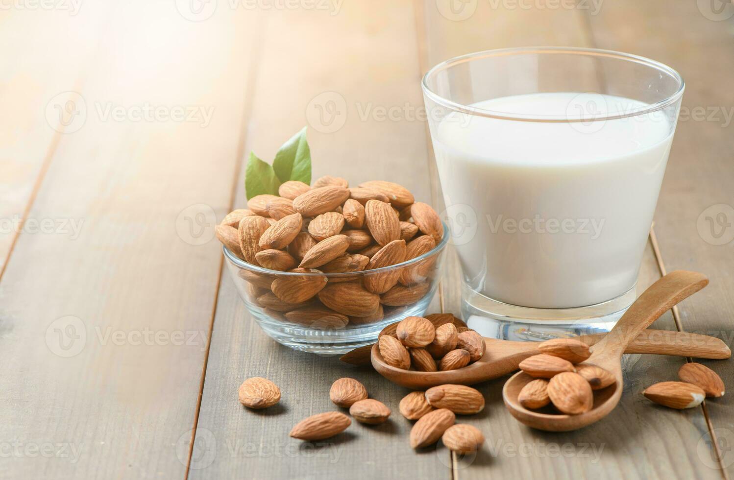 vaso de Leche y Almendras nueces en madera fondo, foto