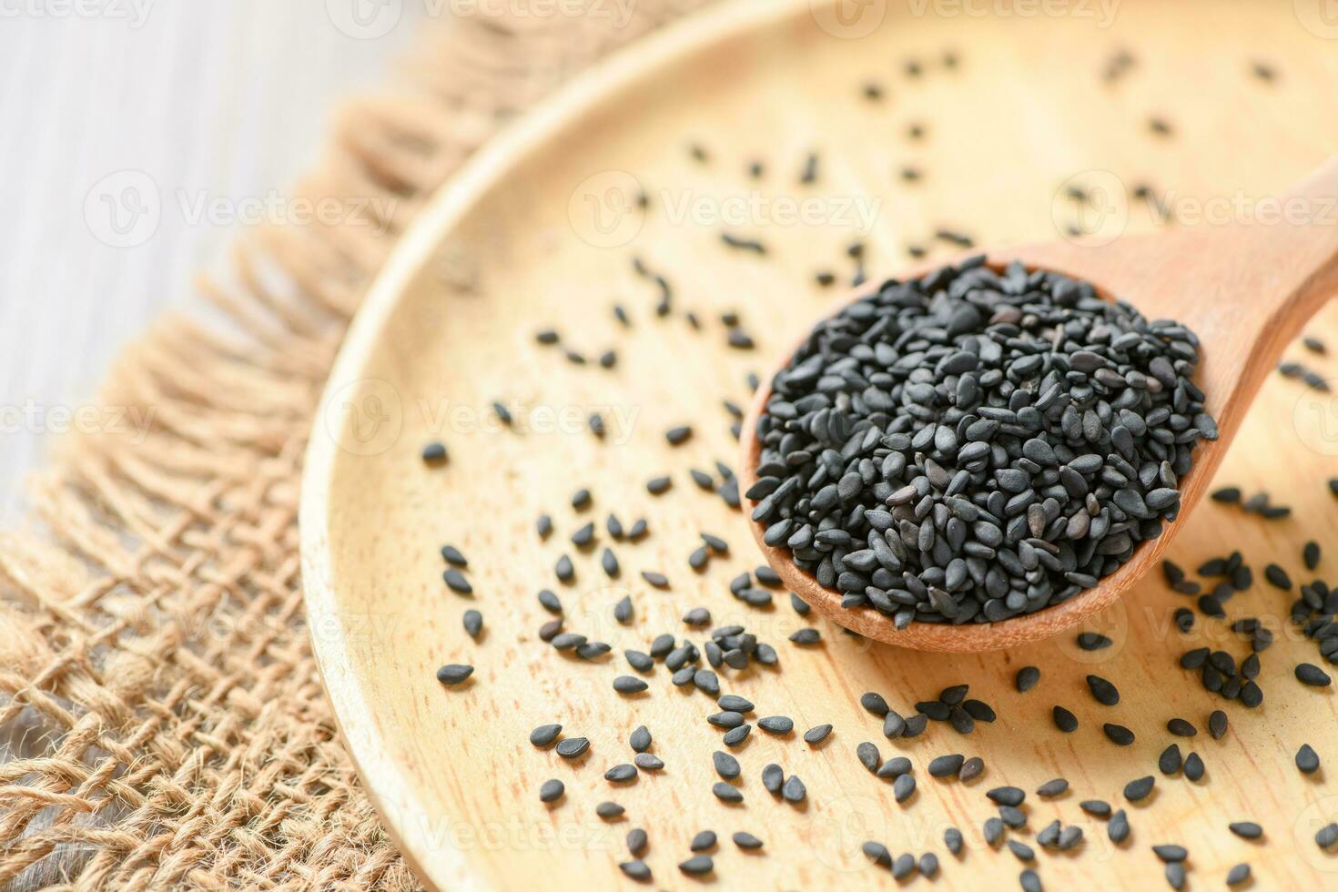 Black sesame seeds on wood spoon. photo