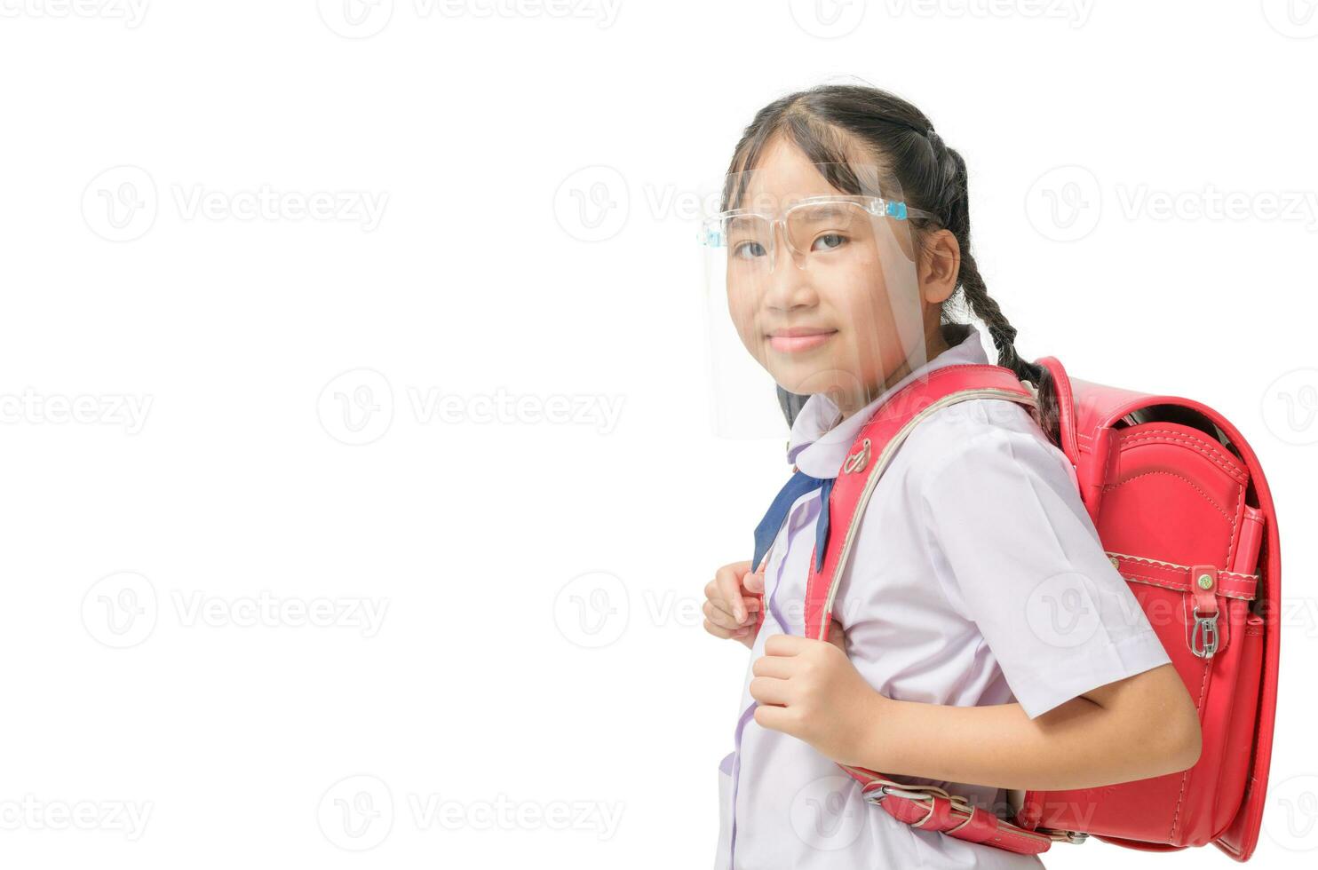 linda niña estudiante vistiendo cara proteger y lleva colegio bolso a Vamos colegio aislado foto