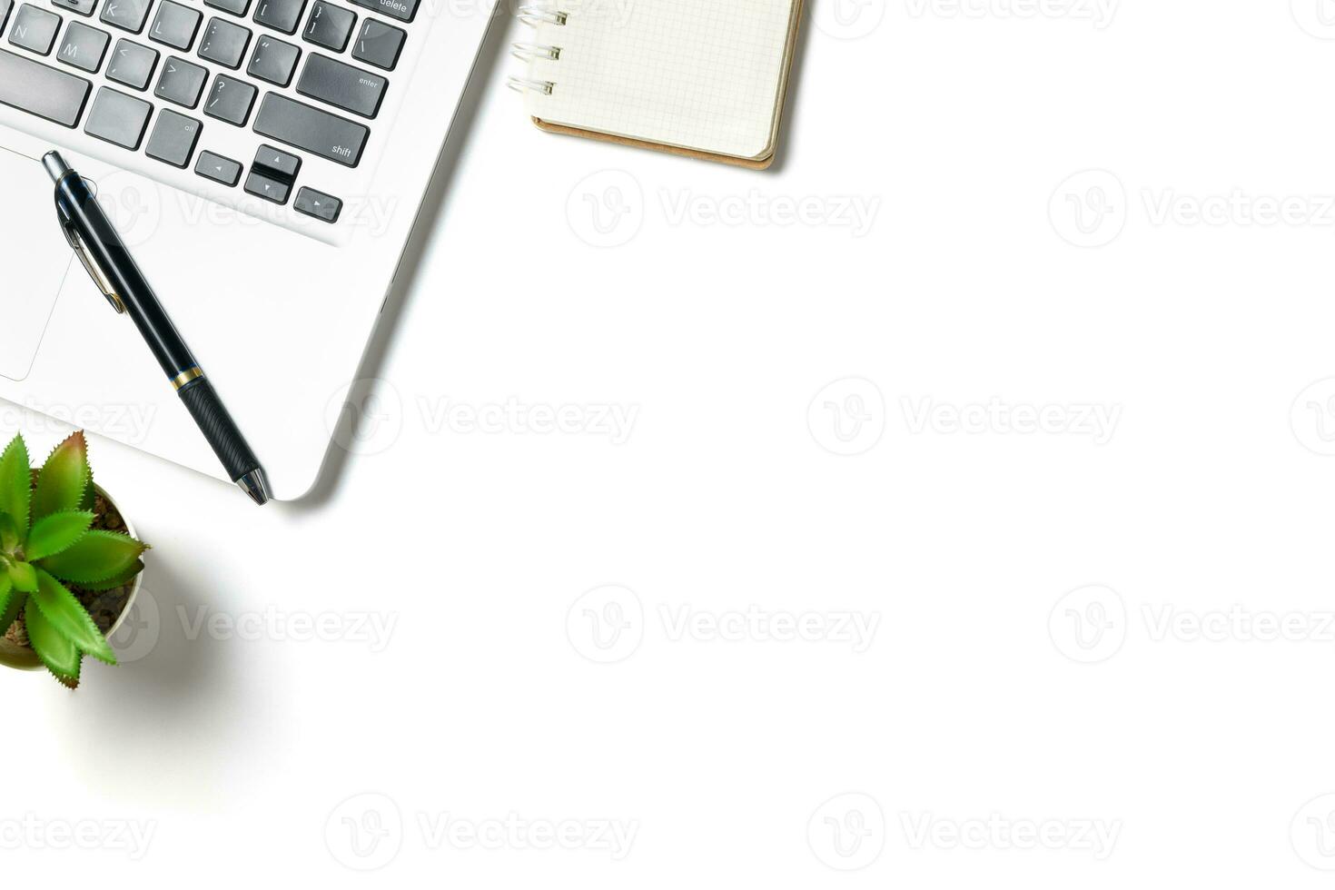 White office desk table with laptop computer and blank notebook isolated on white background. photo