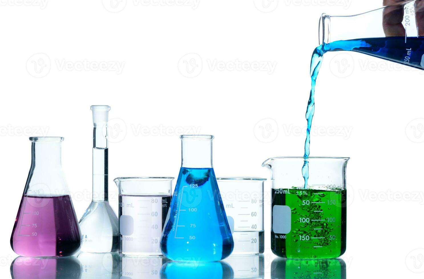 Scientist put blue liquid into measuring beaker  with laboratory glassware photo