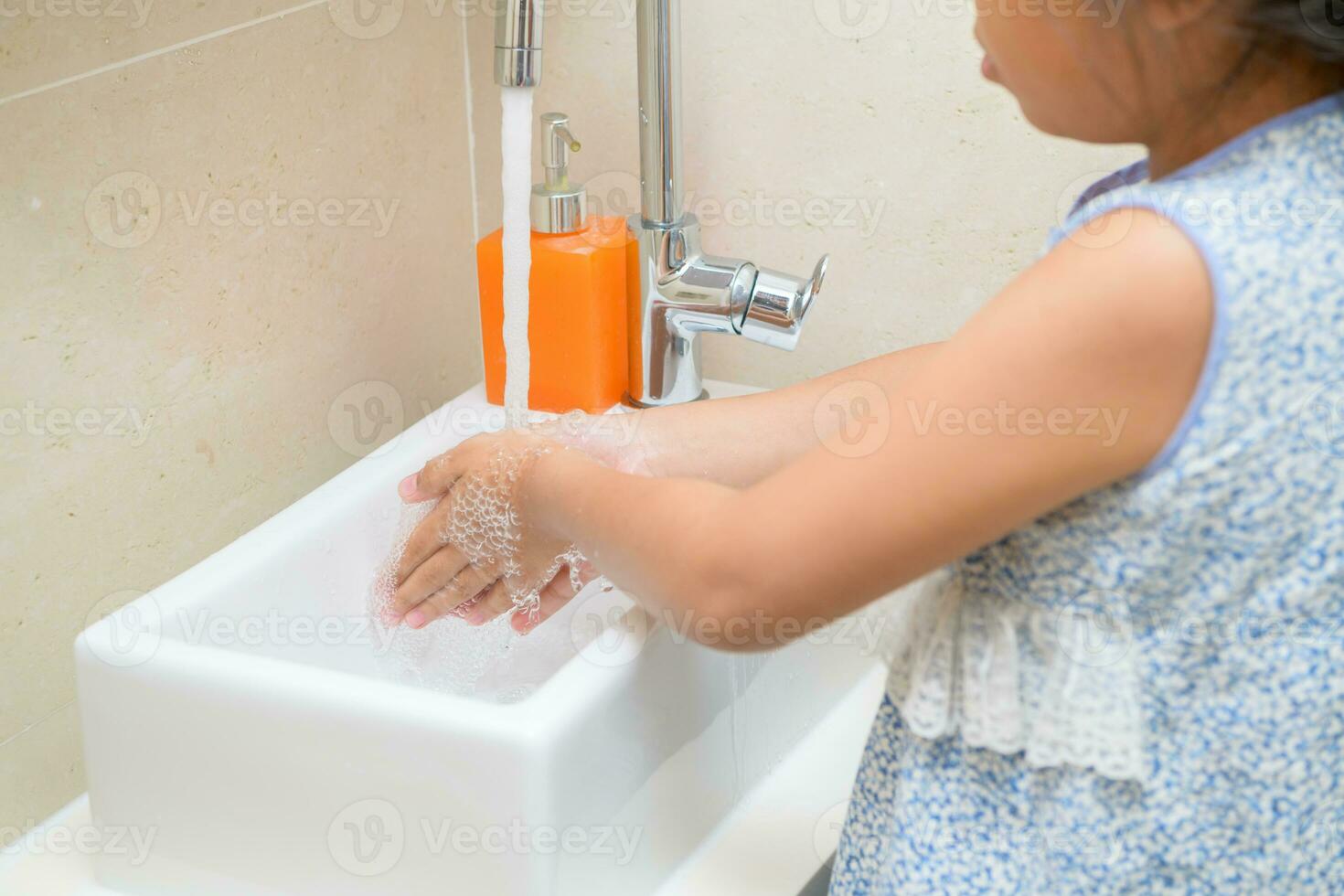 Washing hands child rinsing soap with running water at sink, photo