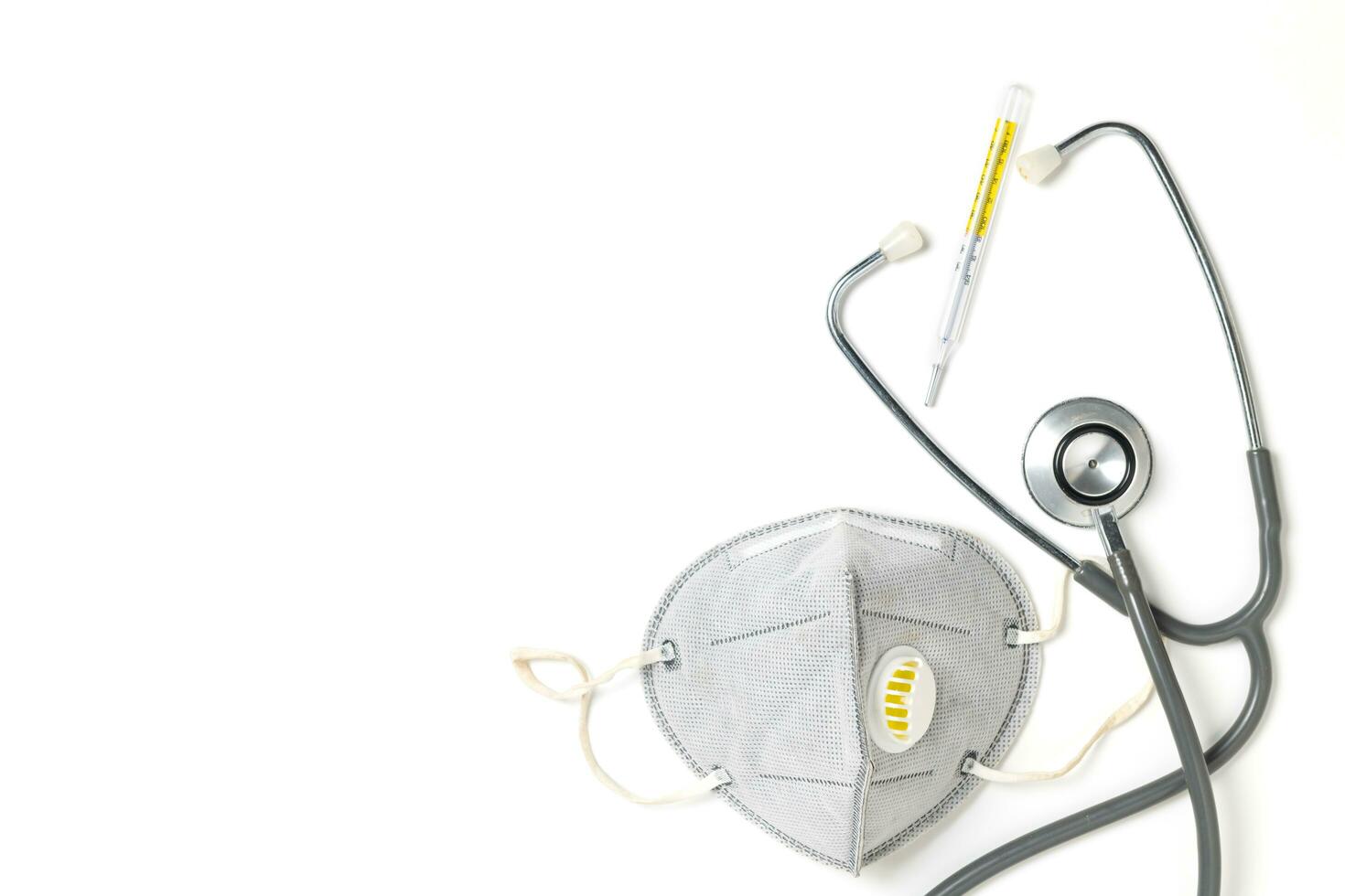 Medical mask with stethoscope and thermometer isolated photo
