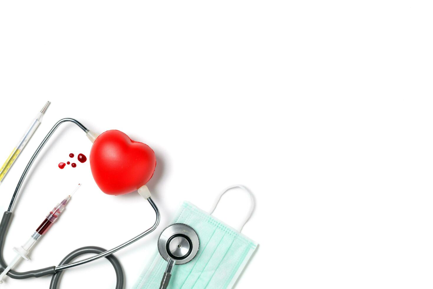 Syring and blood  with stethoscope and little heart isolated photo