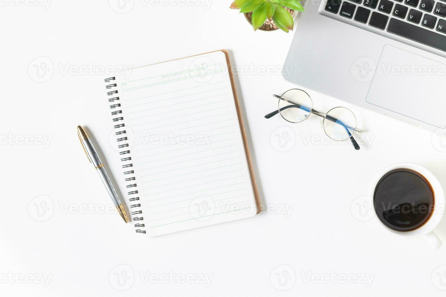 White office desk table Blank notebook with laptop computer photo