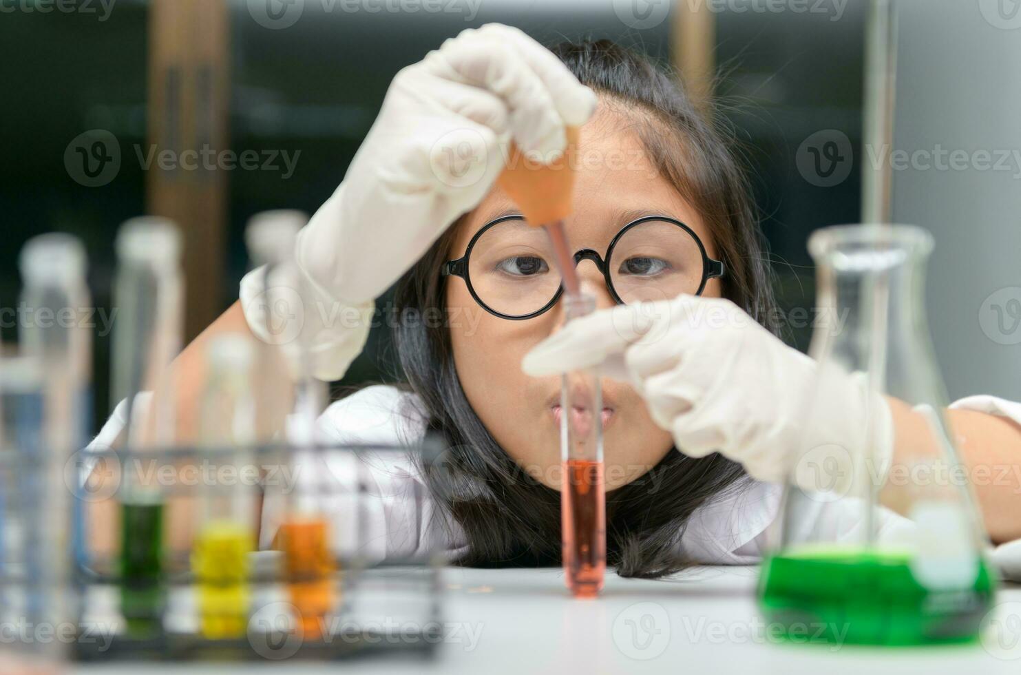 Little scientist use dropper to making experiment. photo
